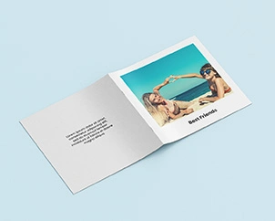 Square photo booklet opened with the spine facing up